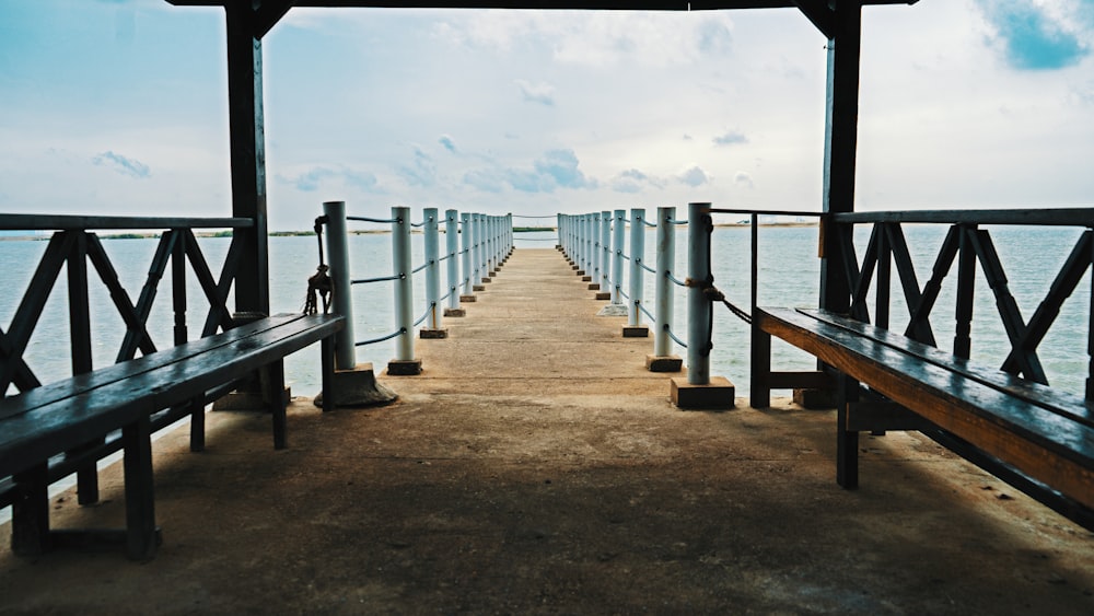 brown wooden dock on sea under blue sky during daytime