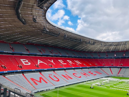 red and white stadium under blue sky during daytime in Allianz arena münchen Germany