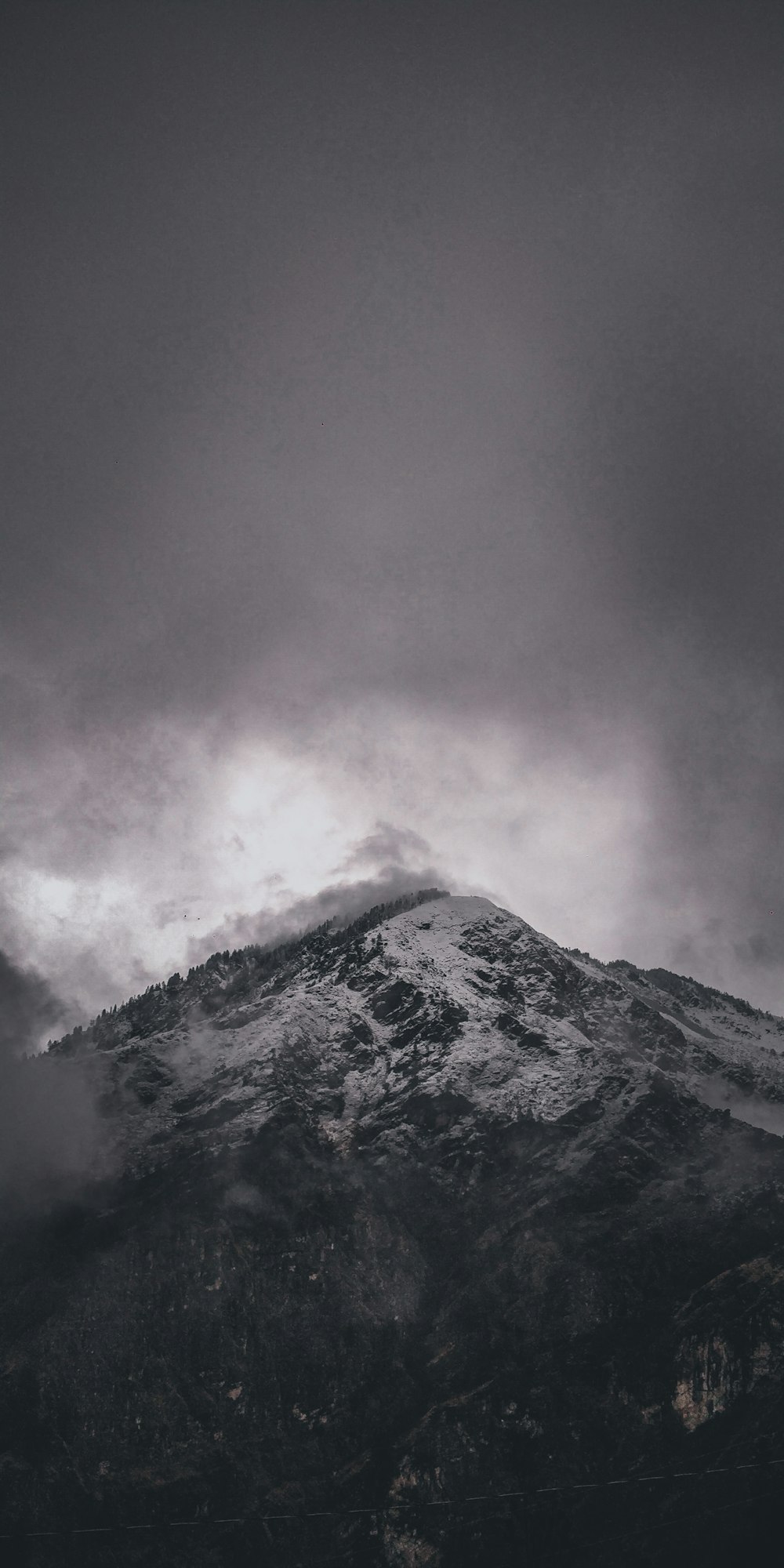 snow covered mountain under cloudy sky