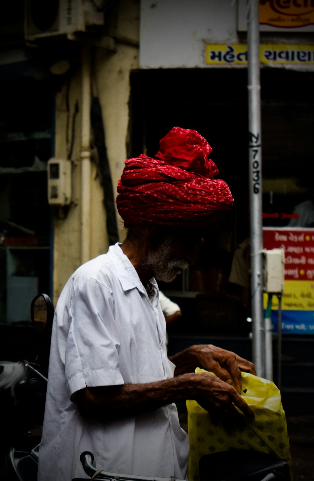 man in white button up shirt and red and white hat holding yellow banana