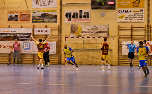 Men playing handball indoors on a court