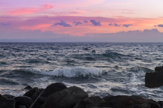 ocean waves crashing on rocks during sunset in Aci Trezza Italy