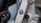 Close-up of a BMW logo placed on a metallic component, likely part of a vehicle's handlebar or steering mechanism. The logo is circular with blue, white, and black colors. Nearby, there are keys and other metallic parts suggesting machinery or automotive context.