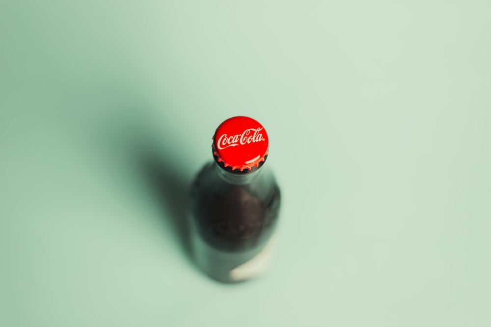Botella de Coca Cola sobre mesa blanca