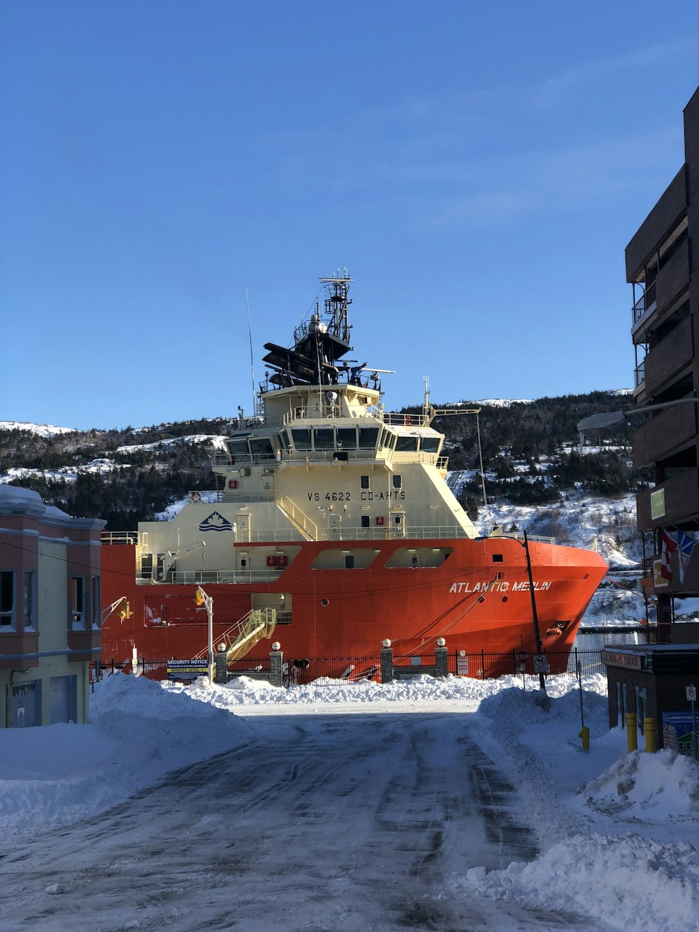 Barco rojo y blanco en terreno cubierto de nieve durante el día