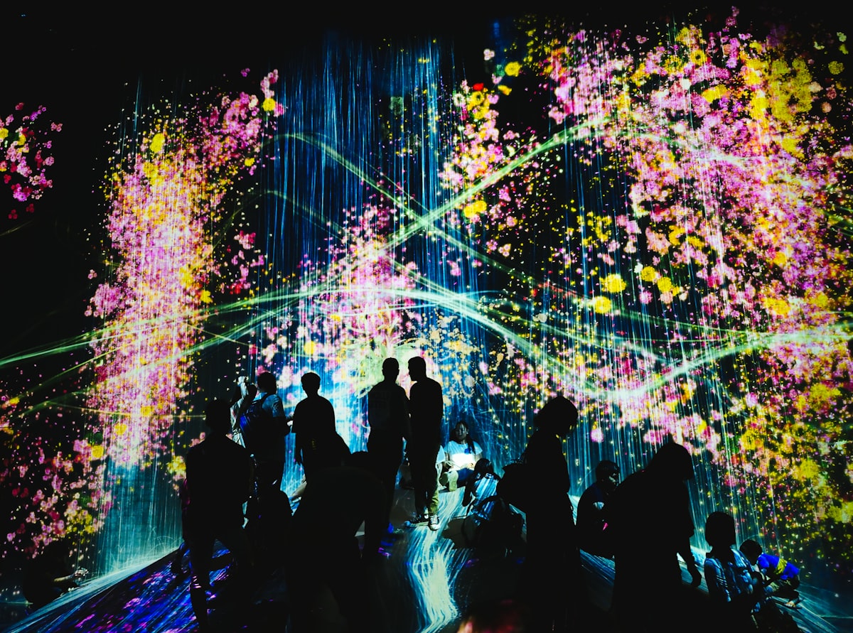 Digital art installation flooding a dark room with light and color at TeamLab Borderless Tokyo