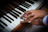 Close-up of hands gracefully playing piano keys during a wedding celebration.