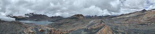 brown and green mountain under white clouds during daytime in Pastoruri Glacier Peru