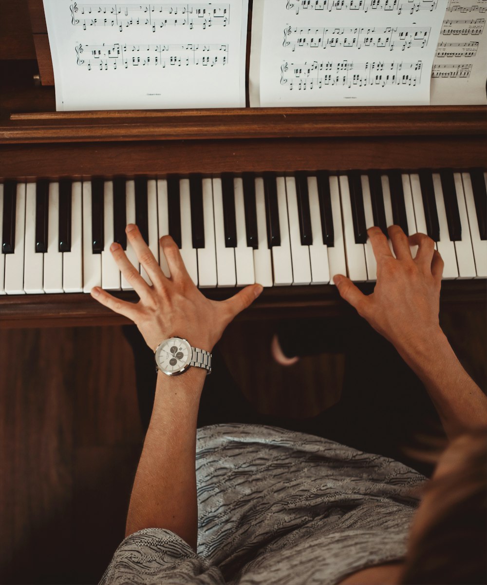 person wearing silver link bracelet round analog watch