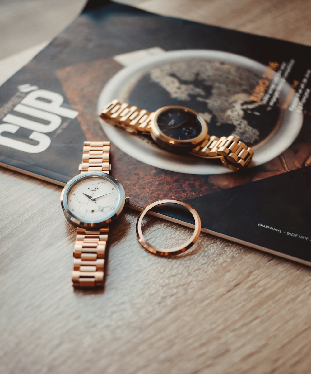 gold and silver round analog watch on black book