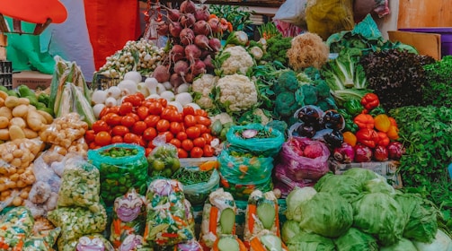 Colorful assortment of fresh vegetables stacked in a wholesale market setting.