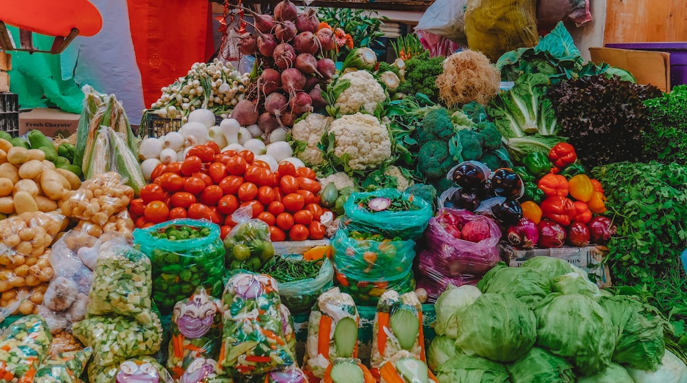 frutas alaranjadas e vegetais verdes em exposição