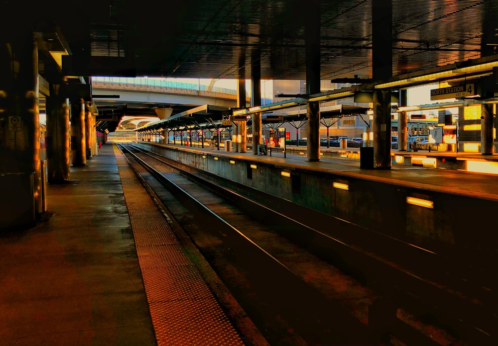 train rail near brown building during night time
