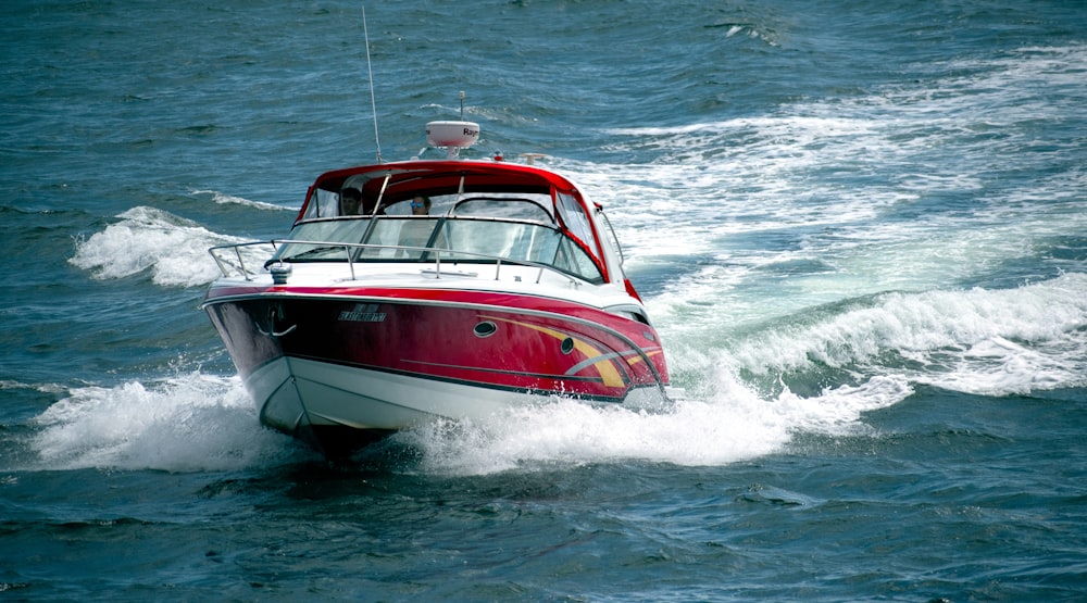 barco branco e vermelho no mar durante o dia