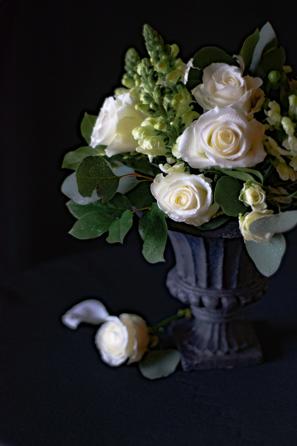 white roses in gray ceramic vase