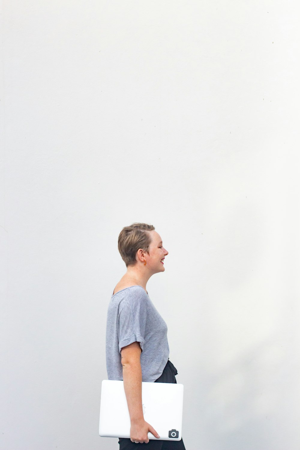 boy in blue crew neck t-shirt standing near white wall
