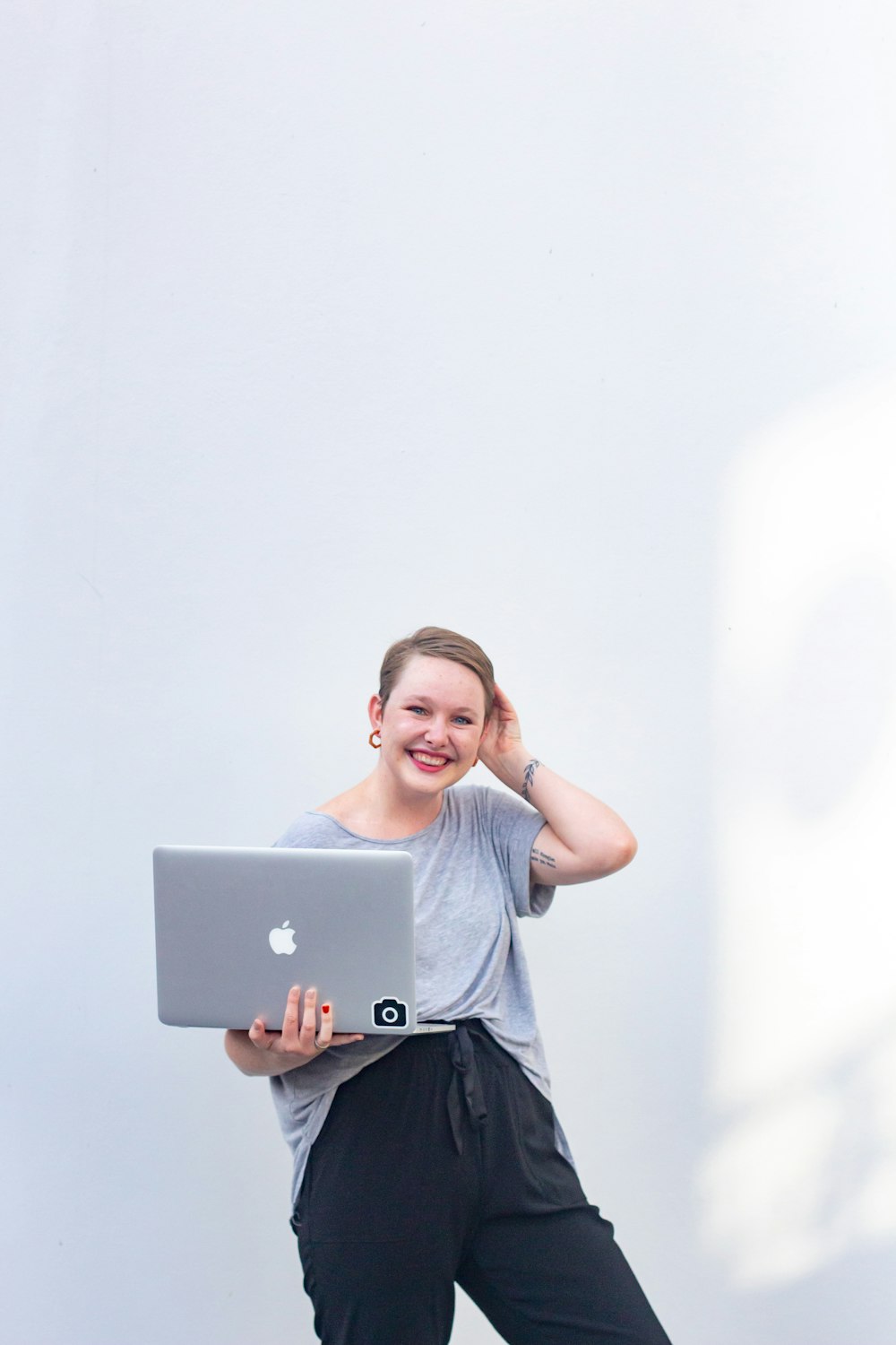 woman in gray crew neck t-shirt holding silver ipad