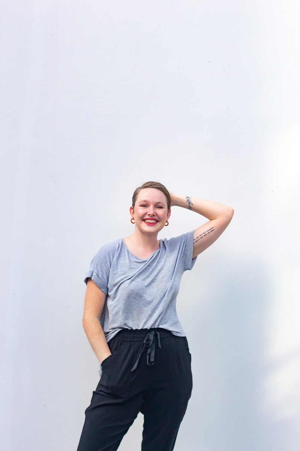 smiling woman in gray crew neck t-shirt and black skirt