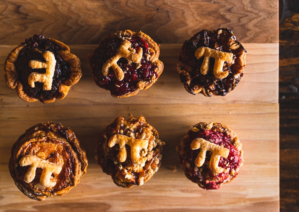 six chocolate cupcakes on brown wooden table