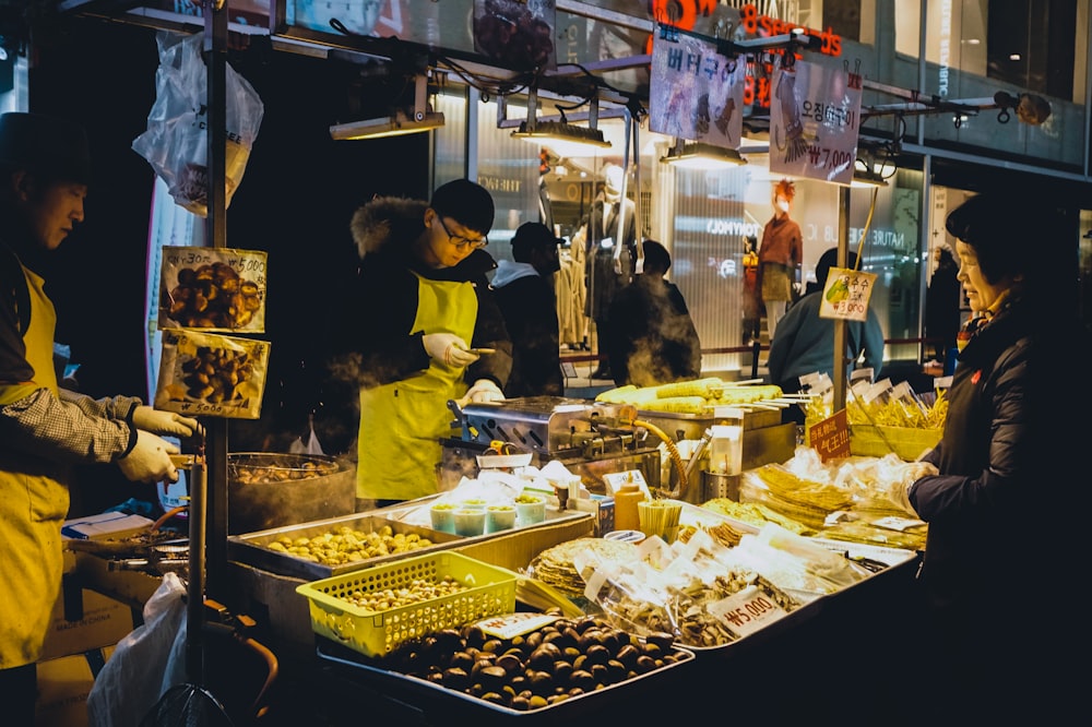 a group of people standing around a food stand