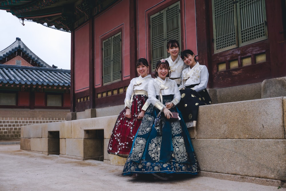 2 women and man sitting on concrete bench