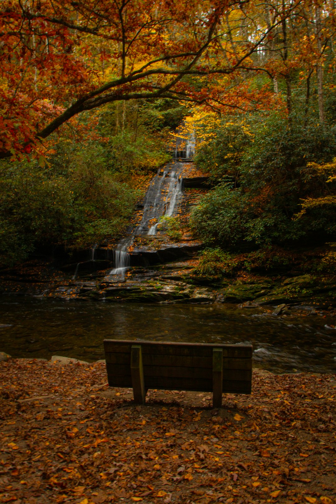 brown wooden bench near water falls during daytime