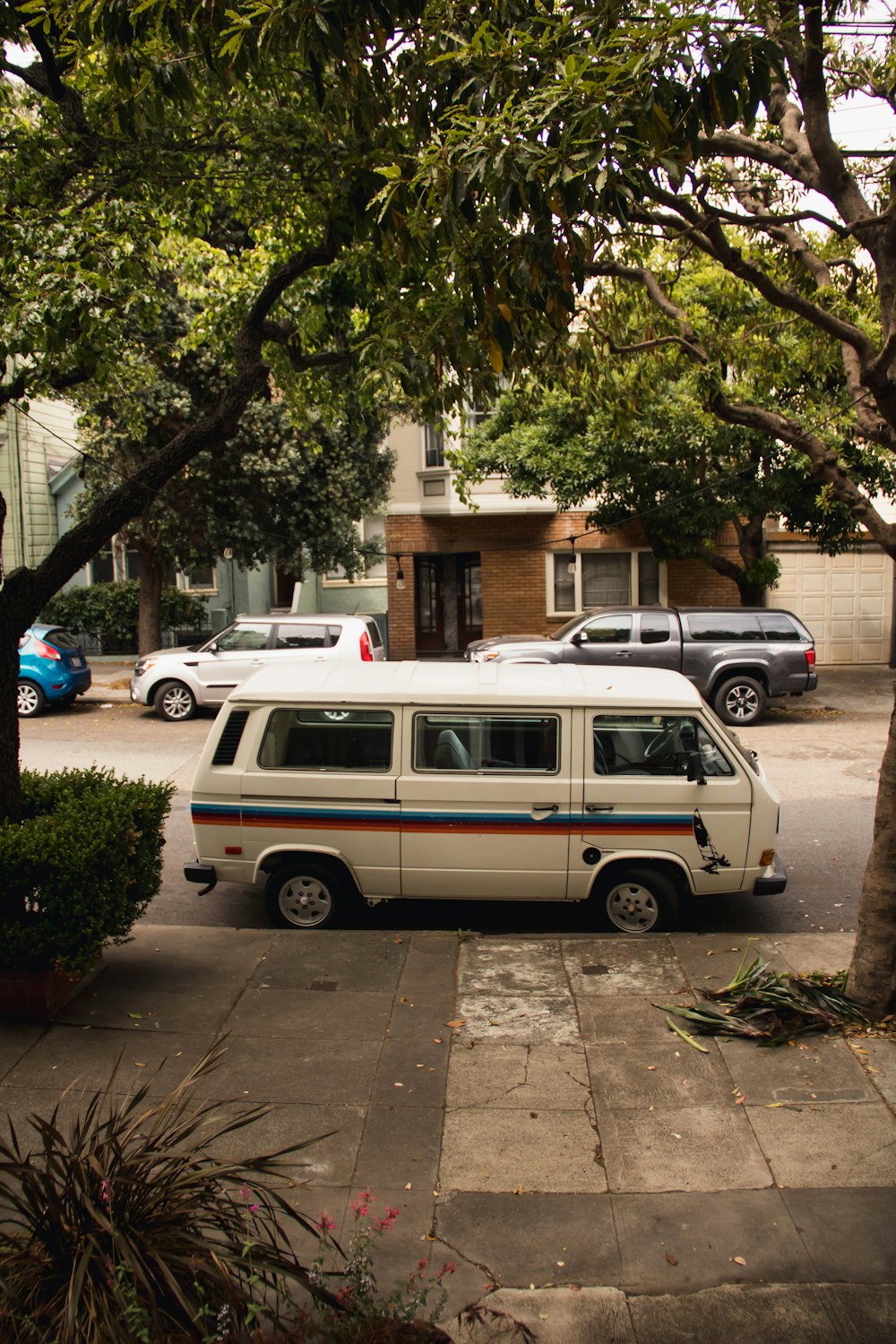 white van parked on sidewalk during daytime