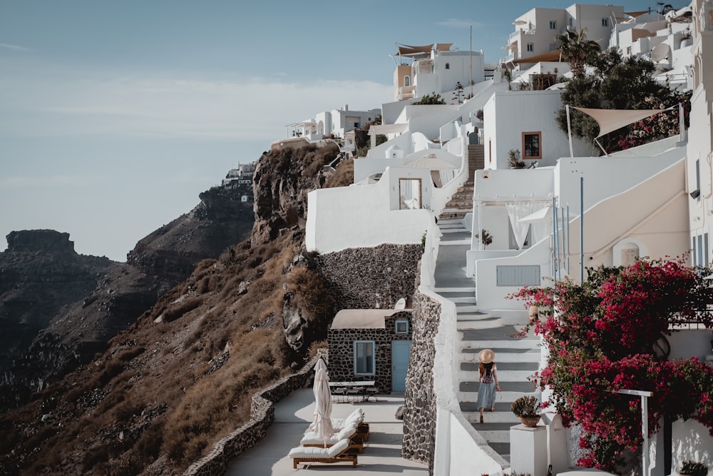 white concrete building on brown rock formation near body of water during daytime