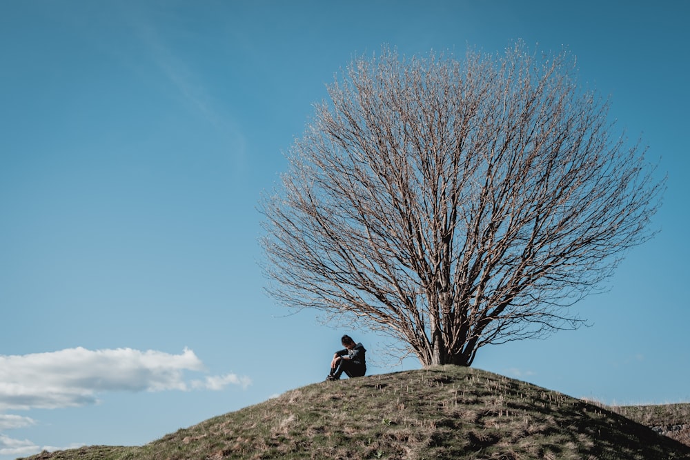 person in black jacket standing on gray rock under blue sky during daytime