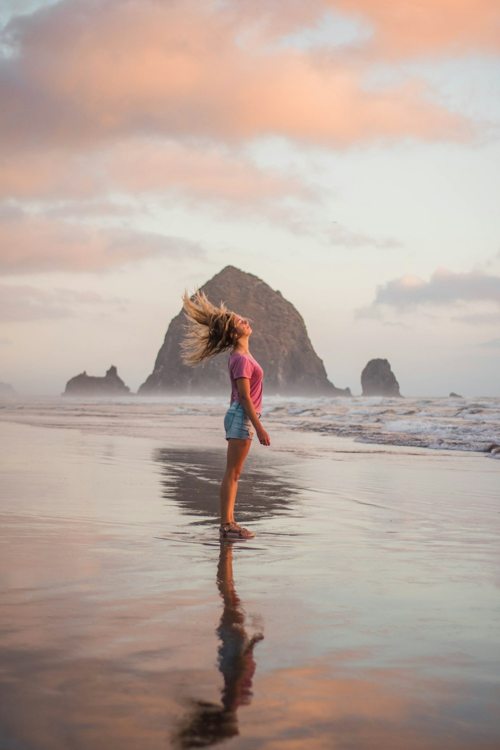 woman in blue dress walking on beach during daytime