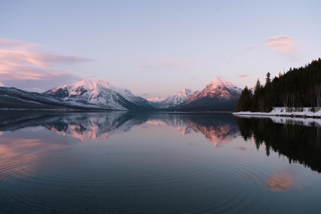 snow covered mountain near lake during daytime