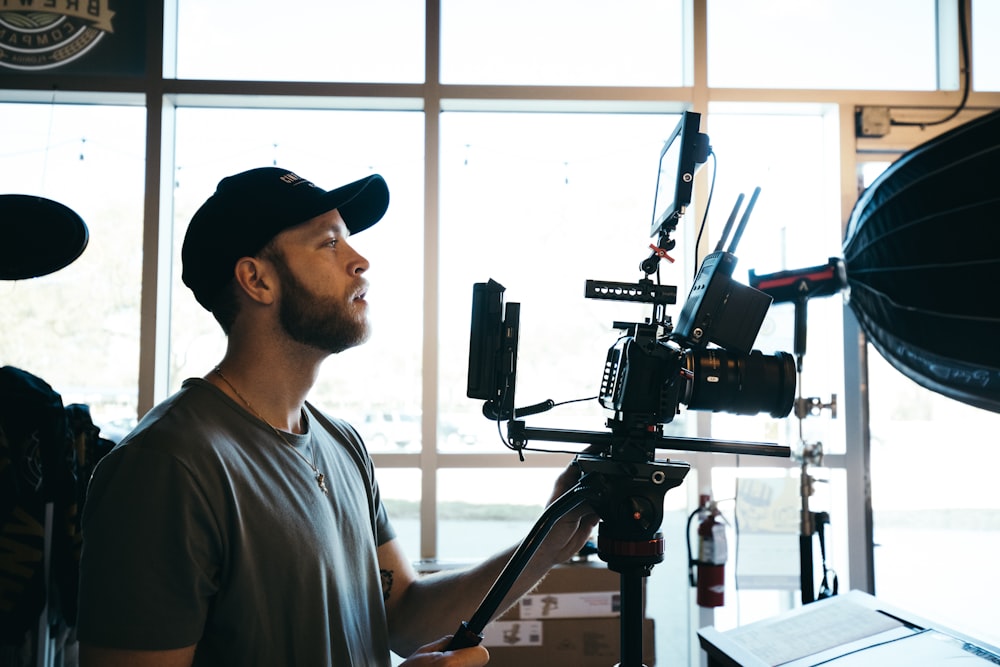 man in gray crew neck t-shirt holding black video camera