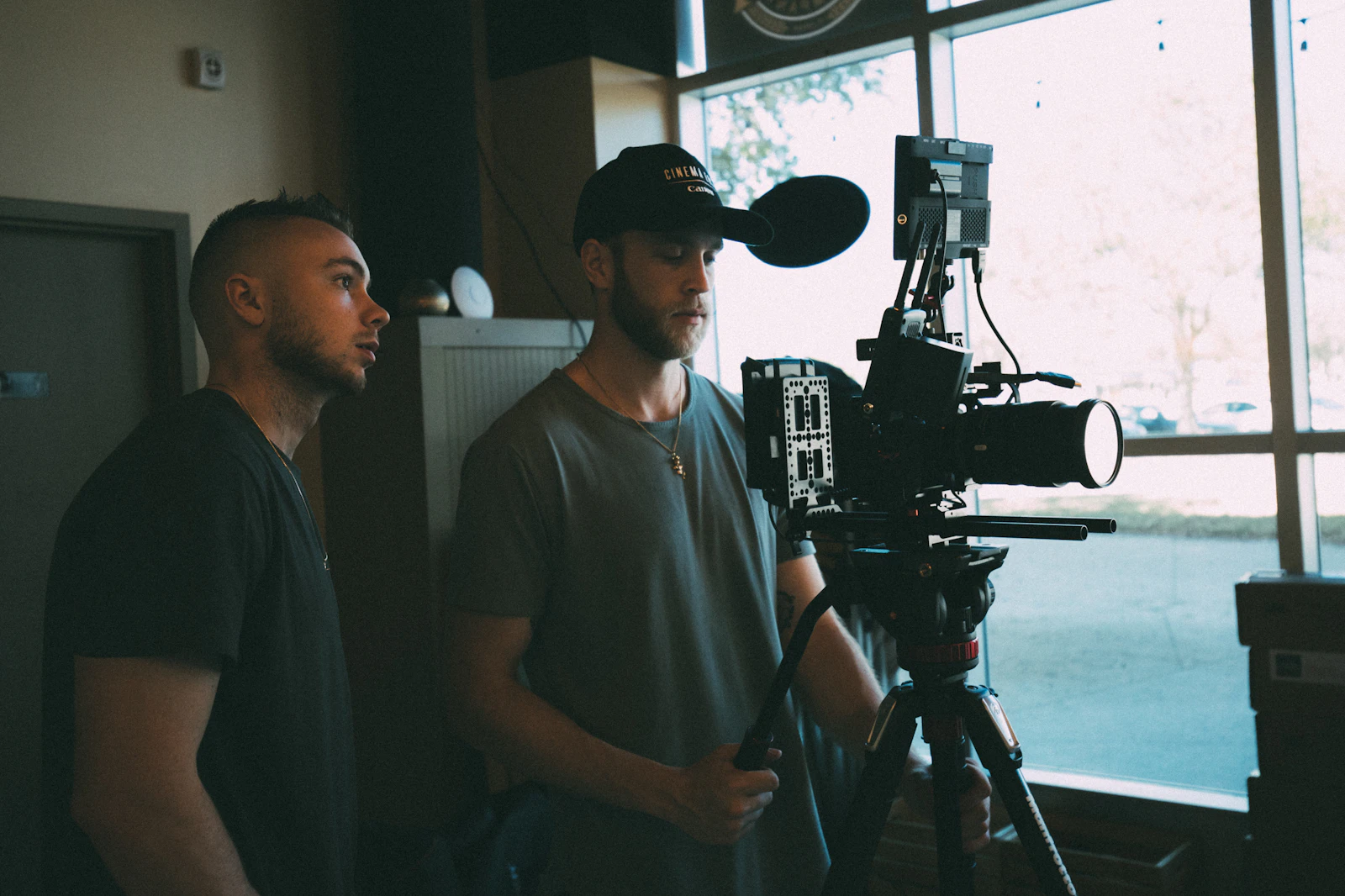 Director and cinematographer at a camera by a window