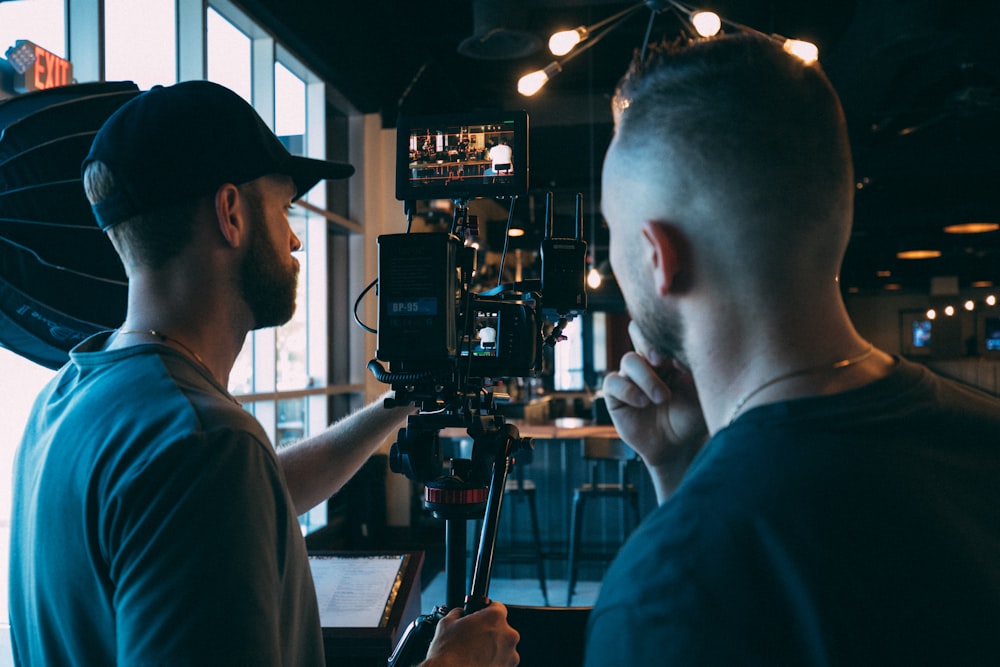 man in blue crew neck t-shirt using black video camera