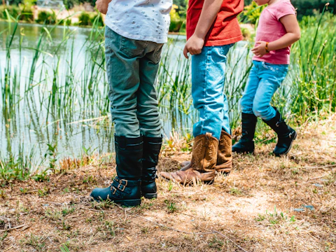 Children playing near a small pond with native plants in the eco-village.