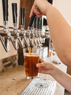 Close-up of a bartender pouring fresh craft beer from a Cygnus Brewing Co. keg.