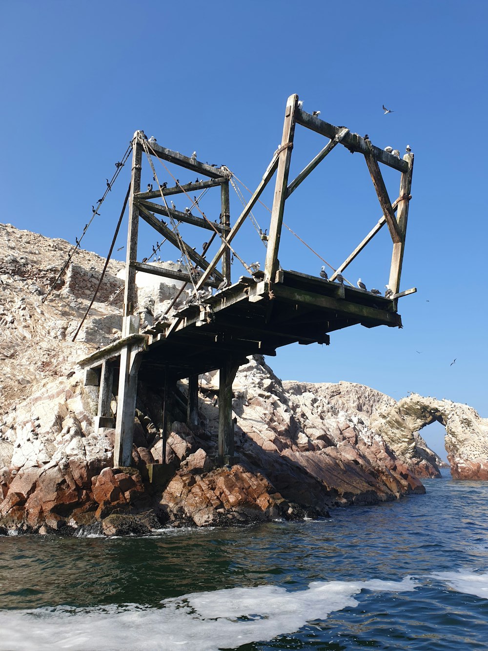 brown wooden bridge over blue sea during daytime