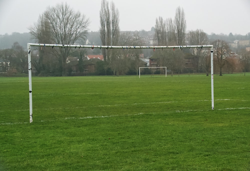 black and white basketball hoop on green grass field during daytime