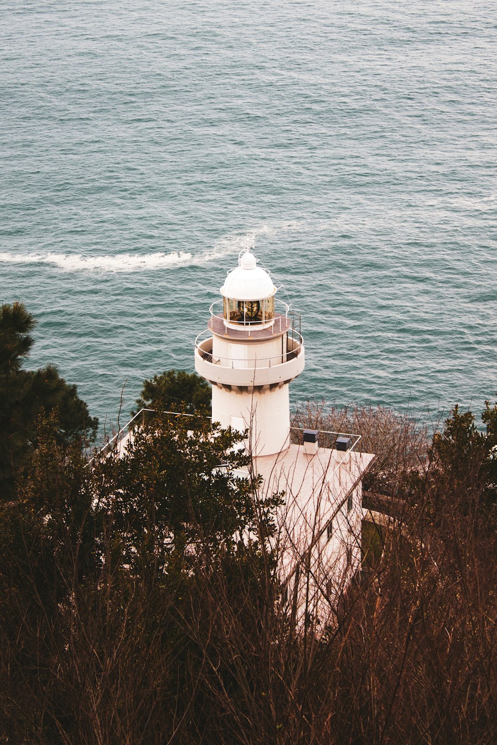 white lighthouse near body of water during daytime