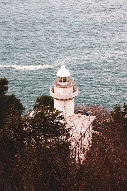 white lighthouse near body of water during daytime in San Sebastián Spain