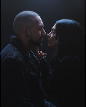 Close-up of a sensual hand gently touching a partner’s face in a dreamy, intimate moment.