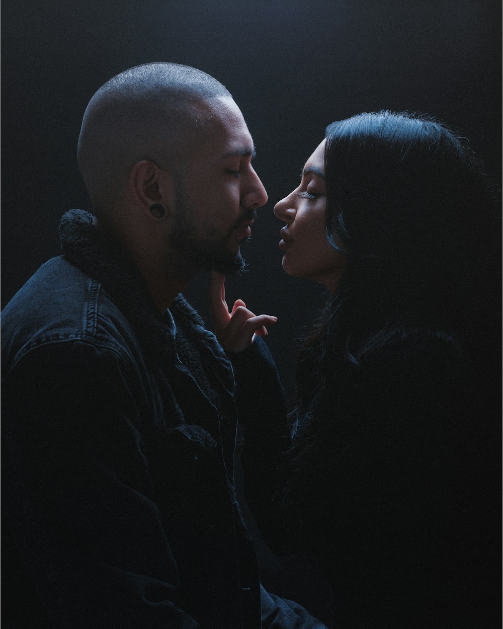 man in black dress shirt kissing woman in black dress