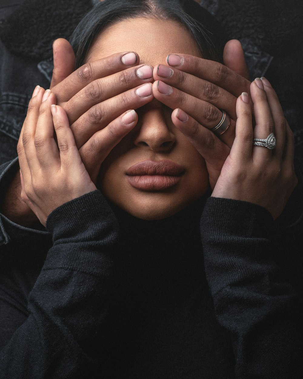 man in black long sleeve shirt covering his face