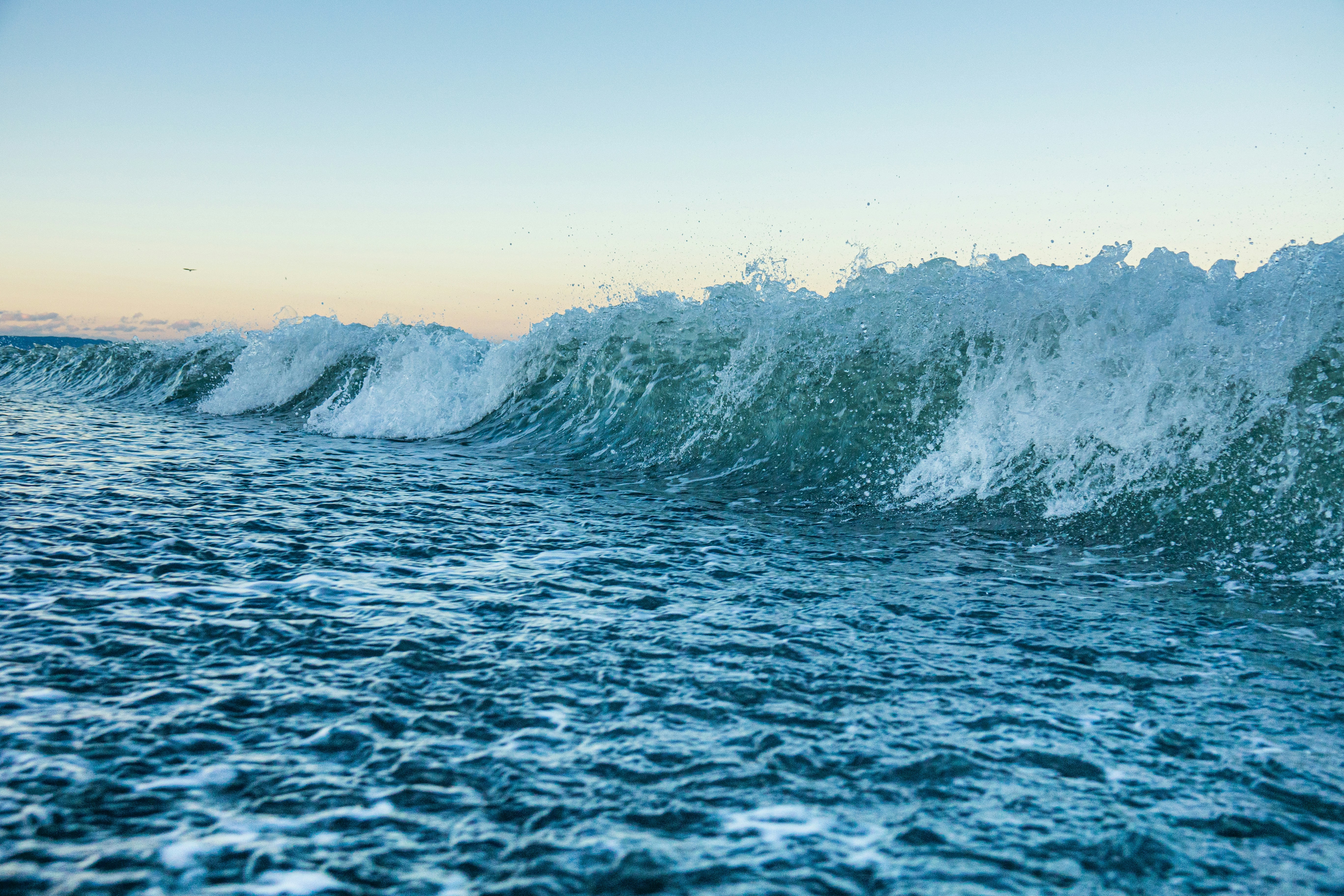 ocean waves crashing on rocky shore during daytime