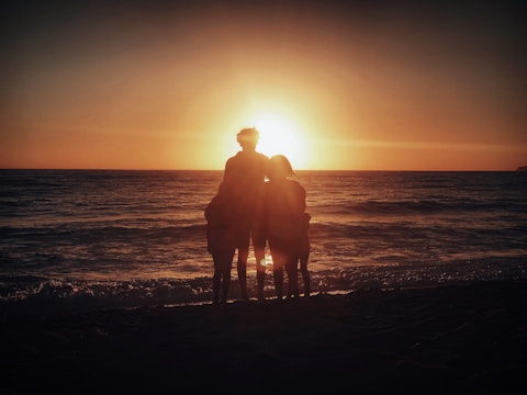A family enjoying a sunset on the beach.