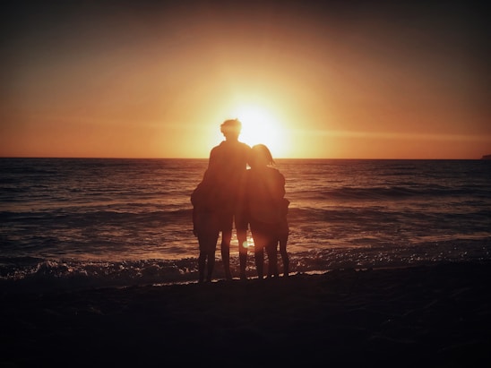 A cheerful family enjoying a sunset at a beachfront all-inclusive resort in Mexico.