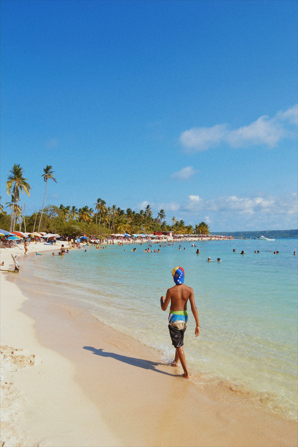 Mujer en bikini azul caminando en la playa durante el día