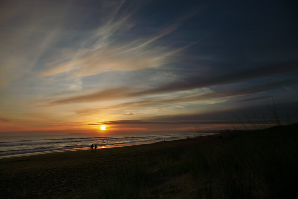 silhouette of people on beach during sunset