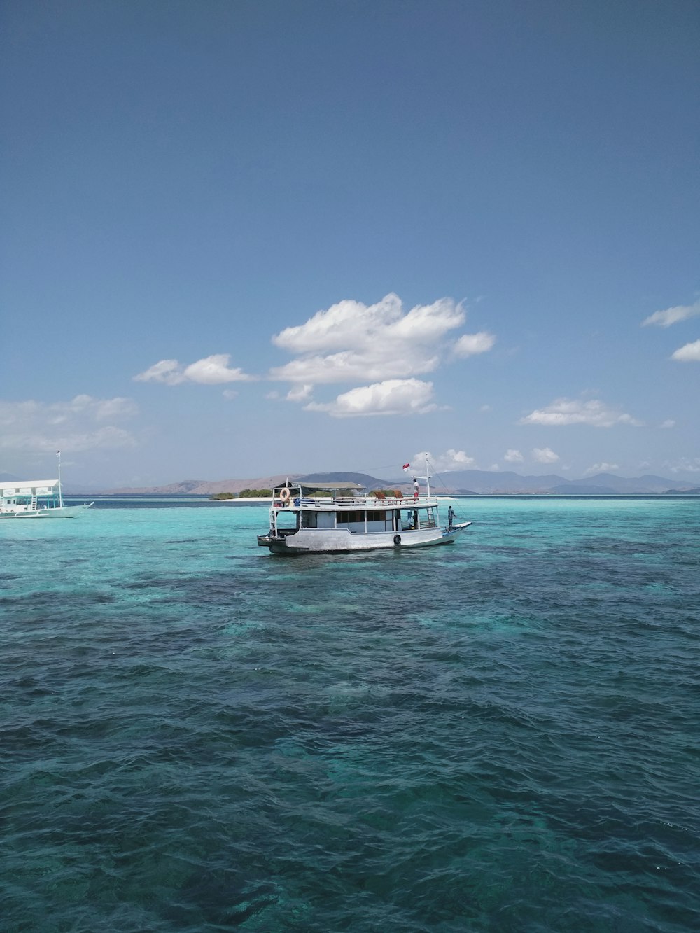 white boat on sea under blue sky during daytime