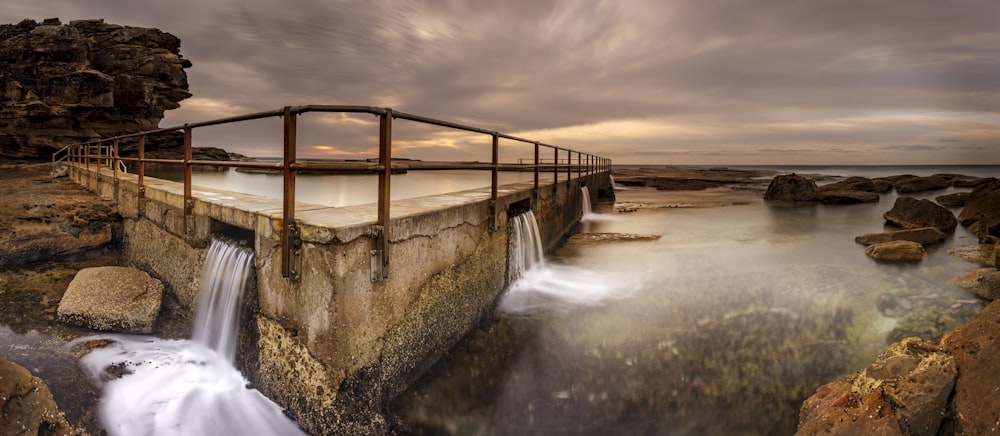 water falls under cloudy sky during daytime